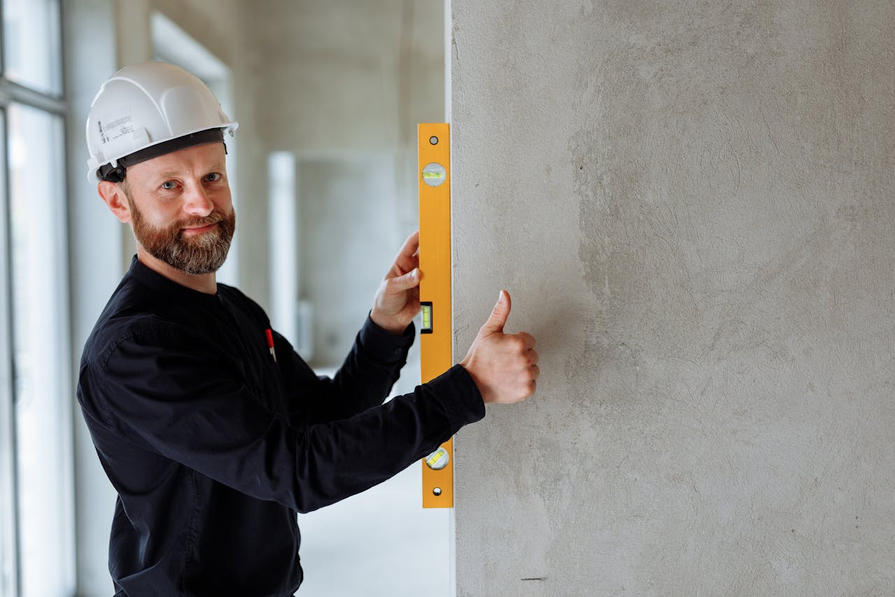 Modern commercial construction project with worker giving thumbs up with level.